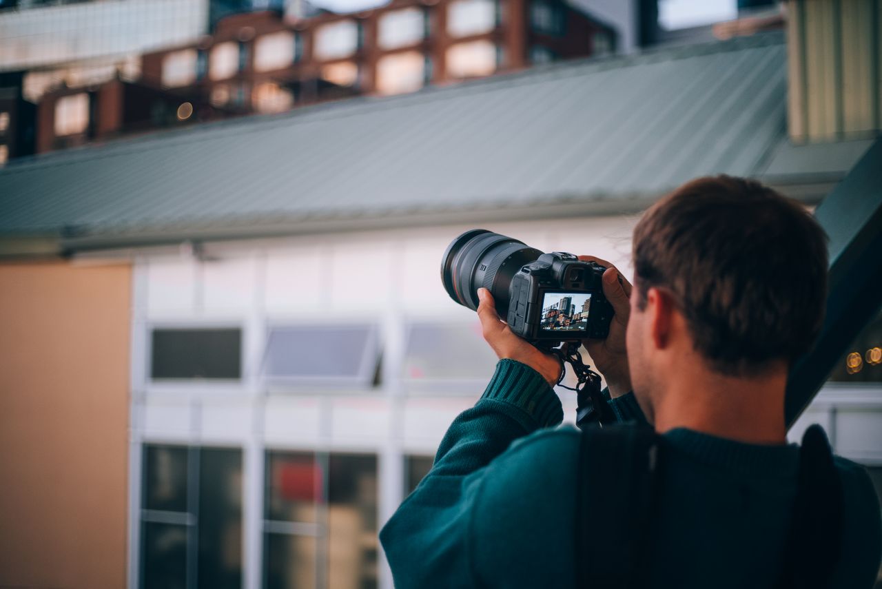 Services A photographer focuses on Seattle's architecture through a camera lens, highlighting the city's urban environment.